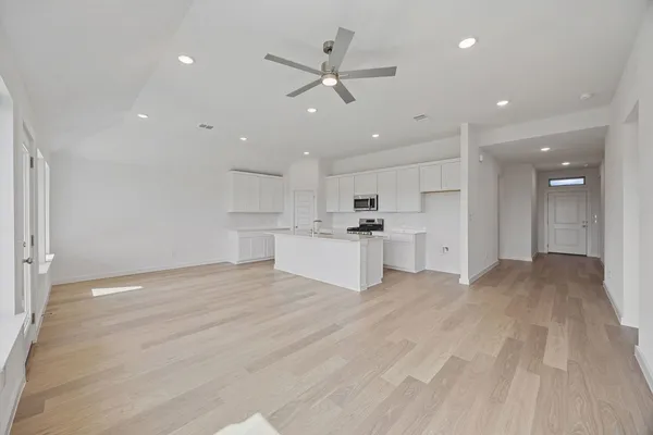 a view of a kitchen with a sink and a stove top oven with wooden floor