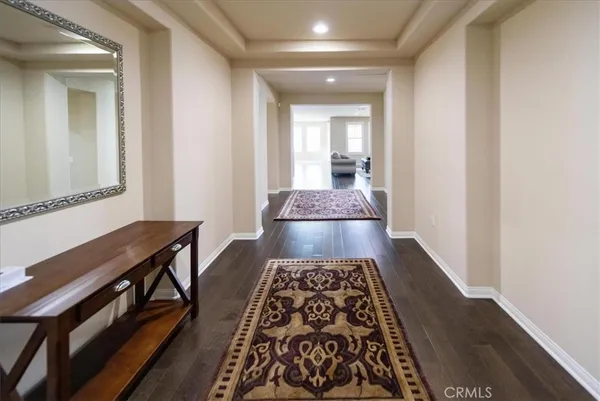 a walk in closet with wooden floor