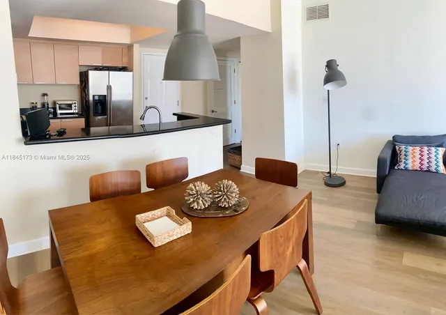 a view of a dining room with furniture and a lamp