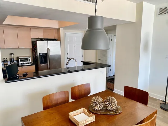 a kitchen with stainless steel appliances granite countertop a sink a stove and a refrigerator