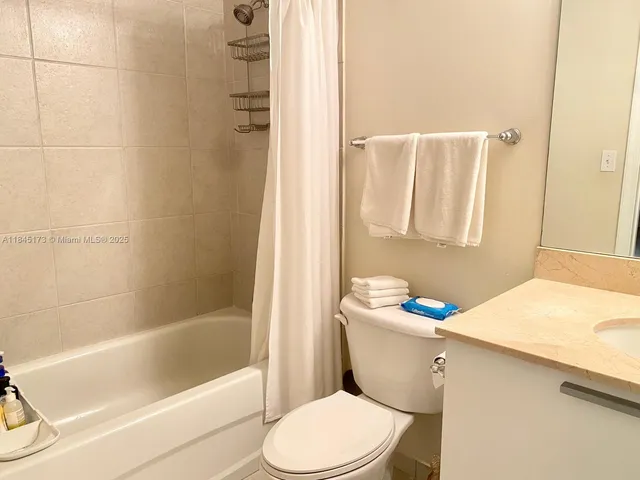 a white toilet sitting next to a bathroom sink