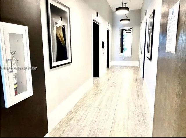 a view of a hallway with windows and entryway