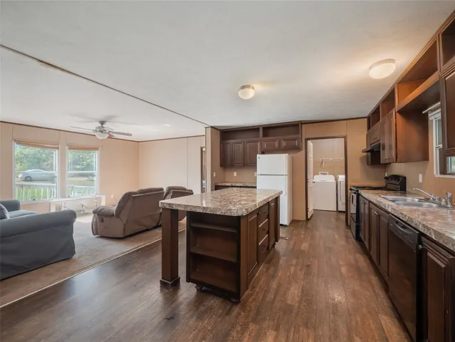 a kitchen with granite countertop a stove and a wooden floors