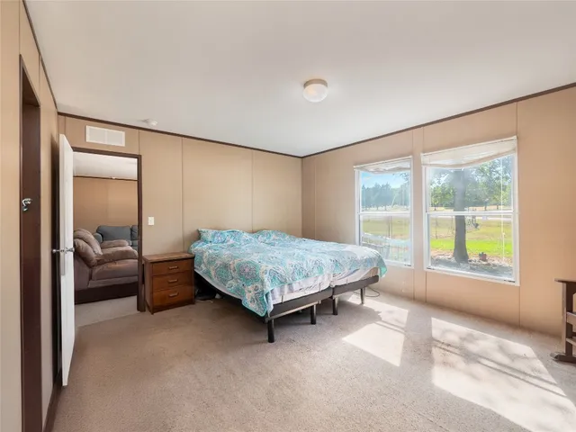 a living room with a bed furniture and a large window