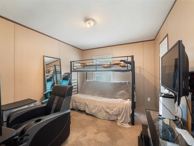 a bedroom with bed and a flat tv screen