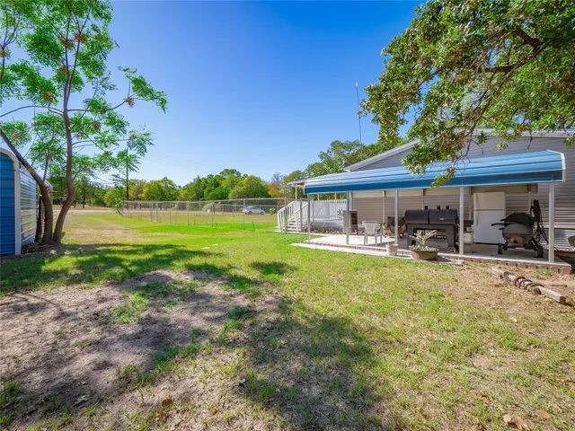 a backyard of a house with table and chairs