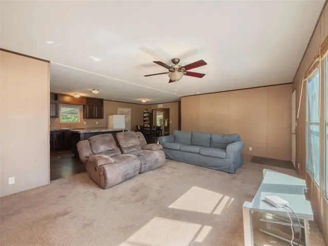 a living room with furniture and a ceiling fan
