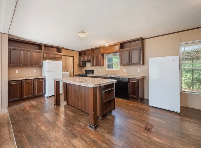 a kitchen with a sink a counter top space stainless steel appliances and a window