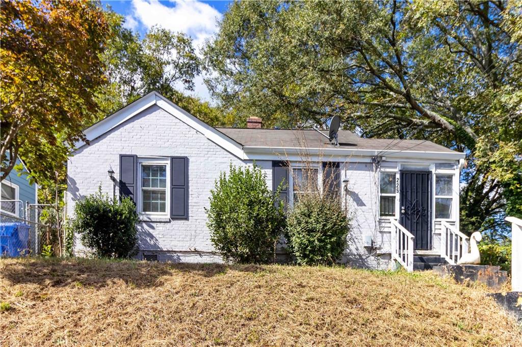 a front view of house with yard and trees around
