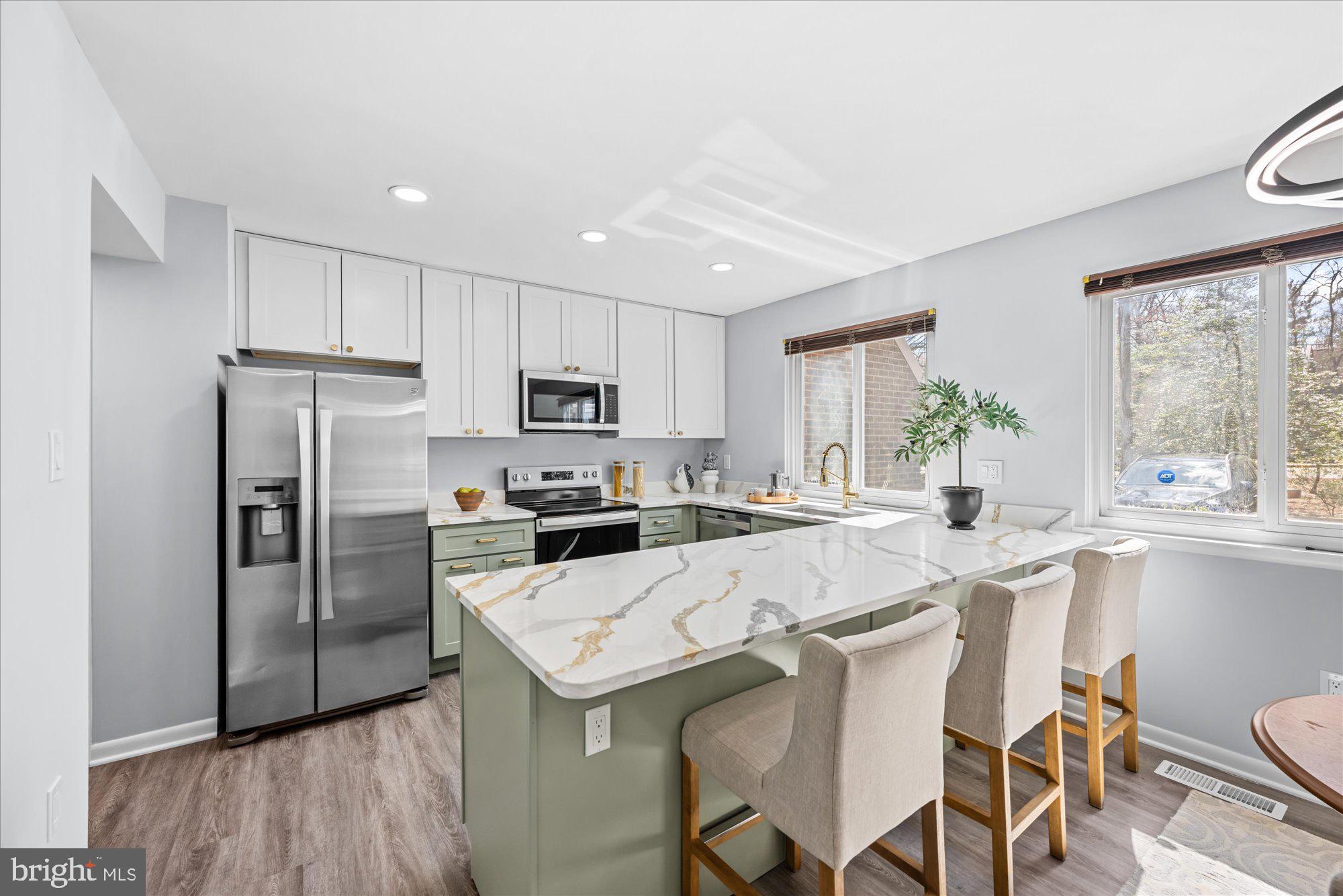 1431 Greenmont Court Reston, VA 20190 - Photo 5 of 16 a kitchen with a refrigerator a stove a sink dishwasher and white cabinets with wooden floor