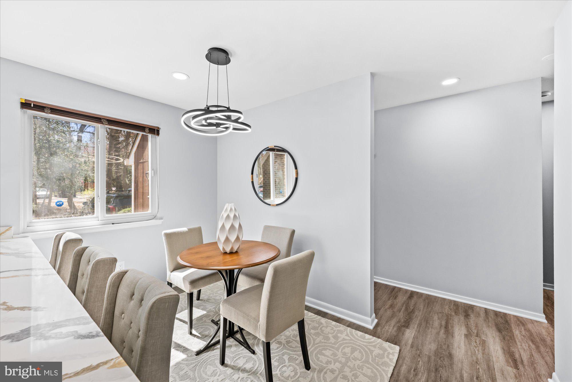 1431 Greenmont Court Reston, VA 20190 - Photo 6 of 16 a dining room with furniture a chandelier and wooden floor