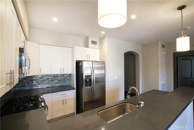 a kitchen with stainless steel appliances granite countertop a refrigerator and a sink