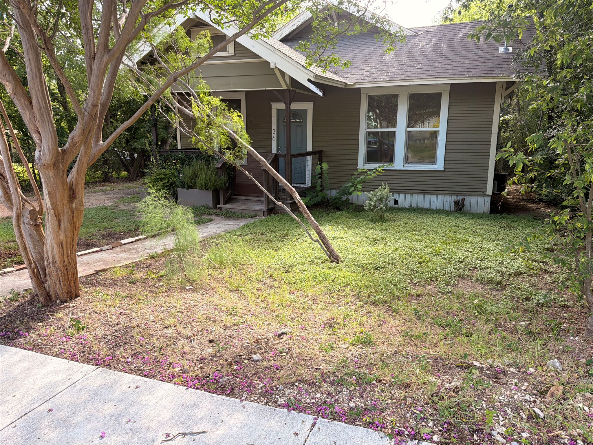 1136 Eleanor Street Austin, TX 78721 - Photo 30 of 30 A charming bungalow with a welcoming porch and abundant surrounding greenery.