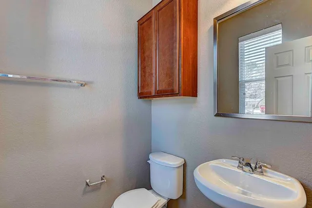 a bathroom with a toilet sink and mirror