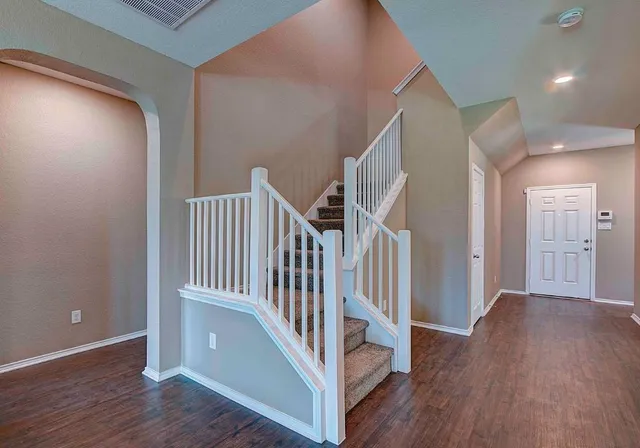 a view of a hallway with wooden floor and entryway