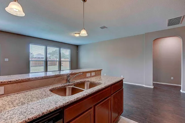 a kitchen with stainless steel appliances granite countertop a sink a oven and a large window