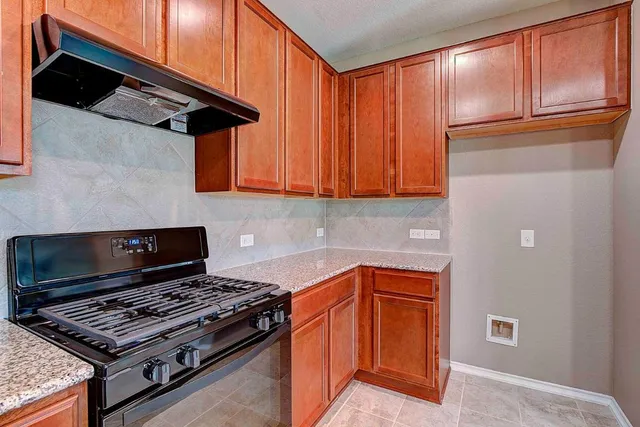 a kitchen with wooden cabinets and a stove top oven