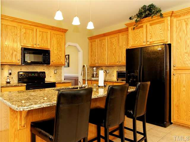 149 Alfred Court Raleigh, NC 27603 - Photo 6 of 24 Kitchen Island w/ Bar, Built In Microwave, Tons Of Cabinets, & Refrigerator Stays w/ Home. Kitchen