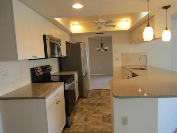 a kitchen with stainless steel appliances granite countertop a sink a stove and a refrigerator