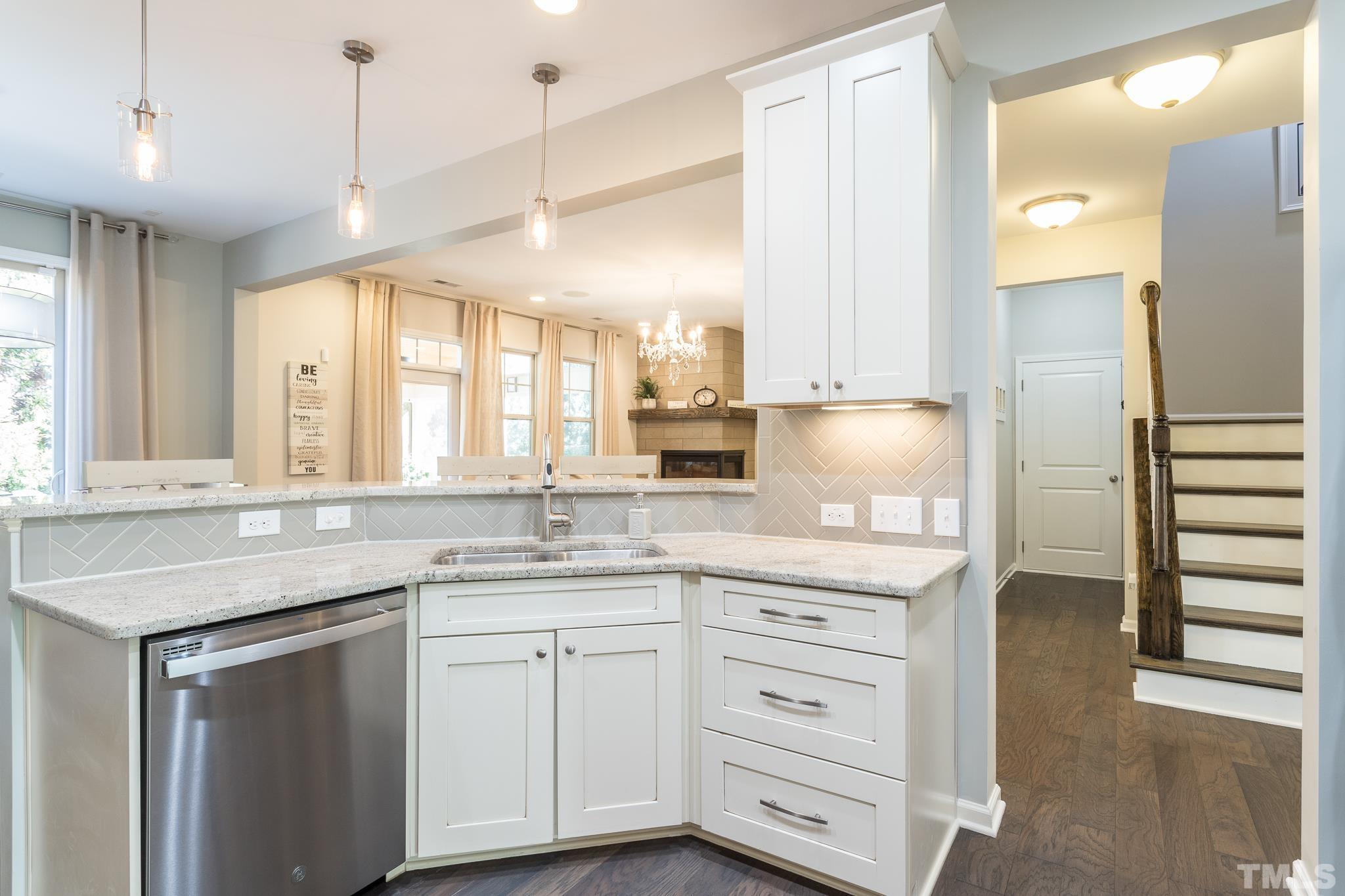 826 Wickham Ridge Road Apex, NC 27539 - Photo 12 of 47 a kitchen with granite countertop white cabinets and white appliances