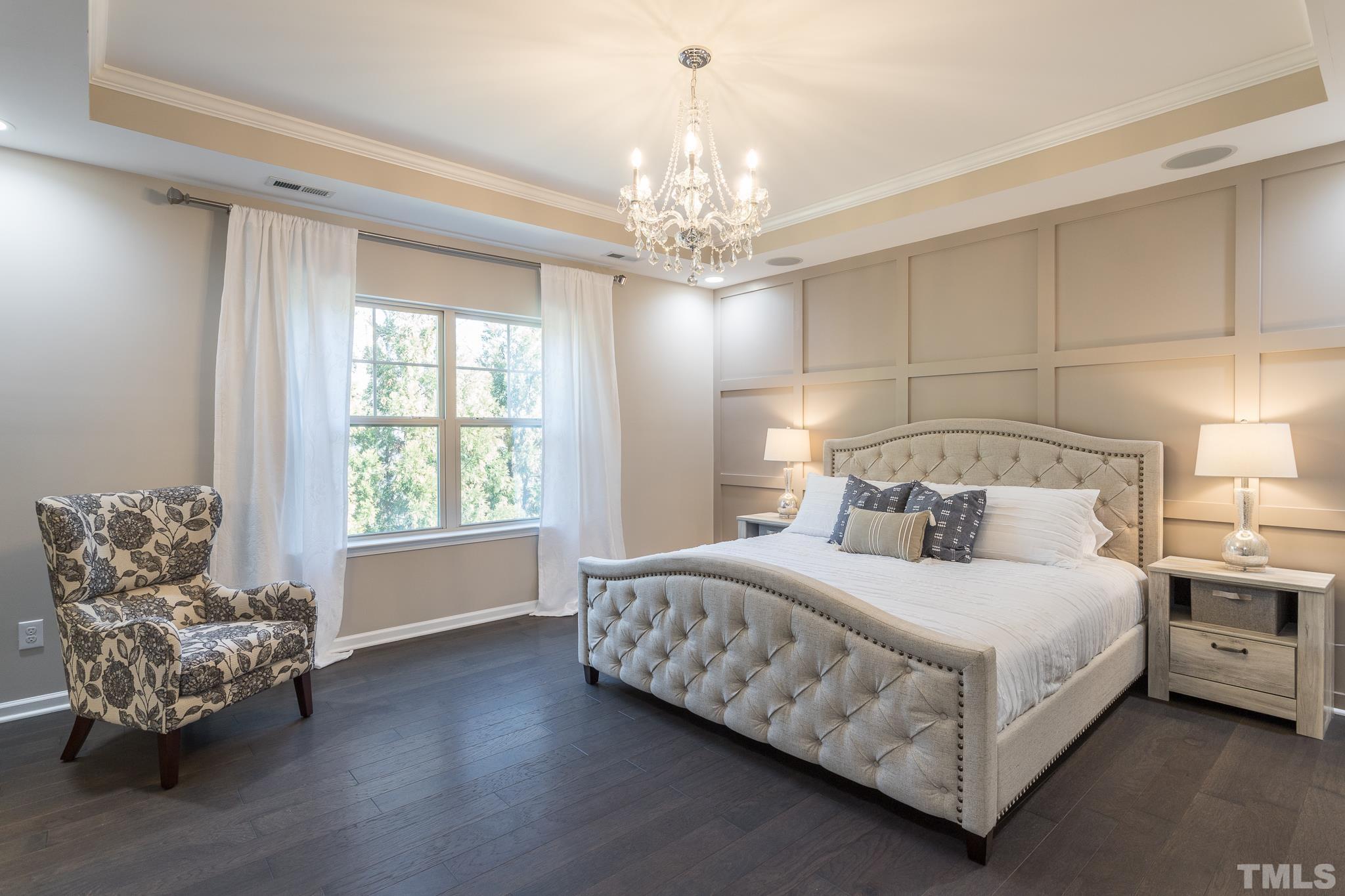 826 Wickham Ridge Road Apex, NC 27539 - Photo 23 of 47 a bedroom with a bed and a chandelier