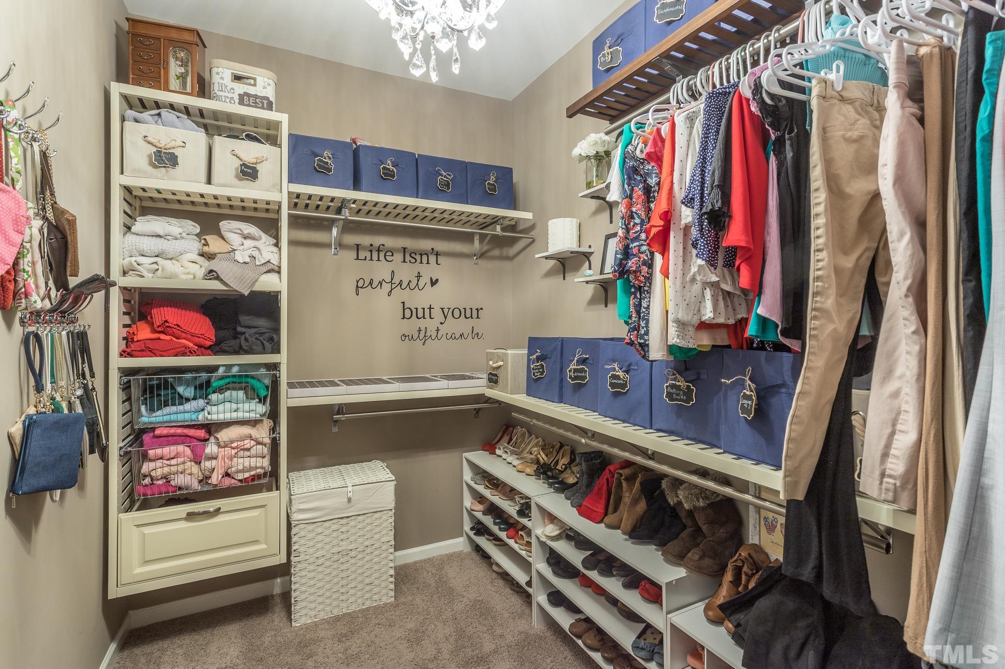 826 Wickham Ridge Road Apex, NC 27539 - Photo 28 of 47 a view of walk in closet with clothes and shoes