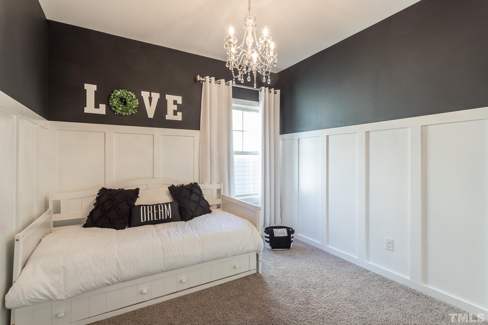 826 Wickham Ridge Road Apex, NC 27539 - Photo 29 of 47 a bedroom with a bed and a chandelier