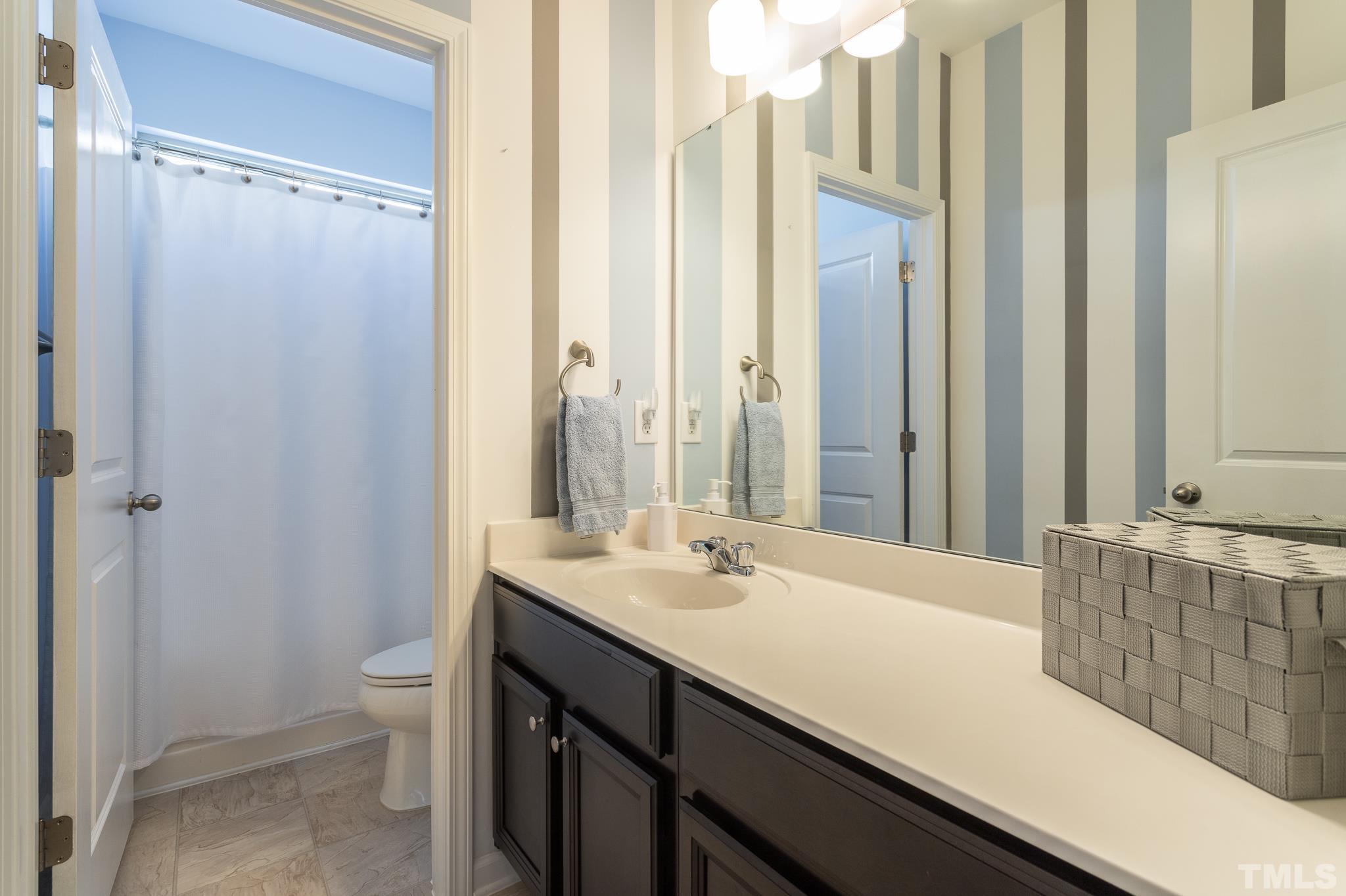 826 Wickham Ridge Road Apex, NC 27539 - Photo 32 of 47 a bathroom with a sink and a mirror