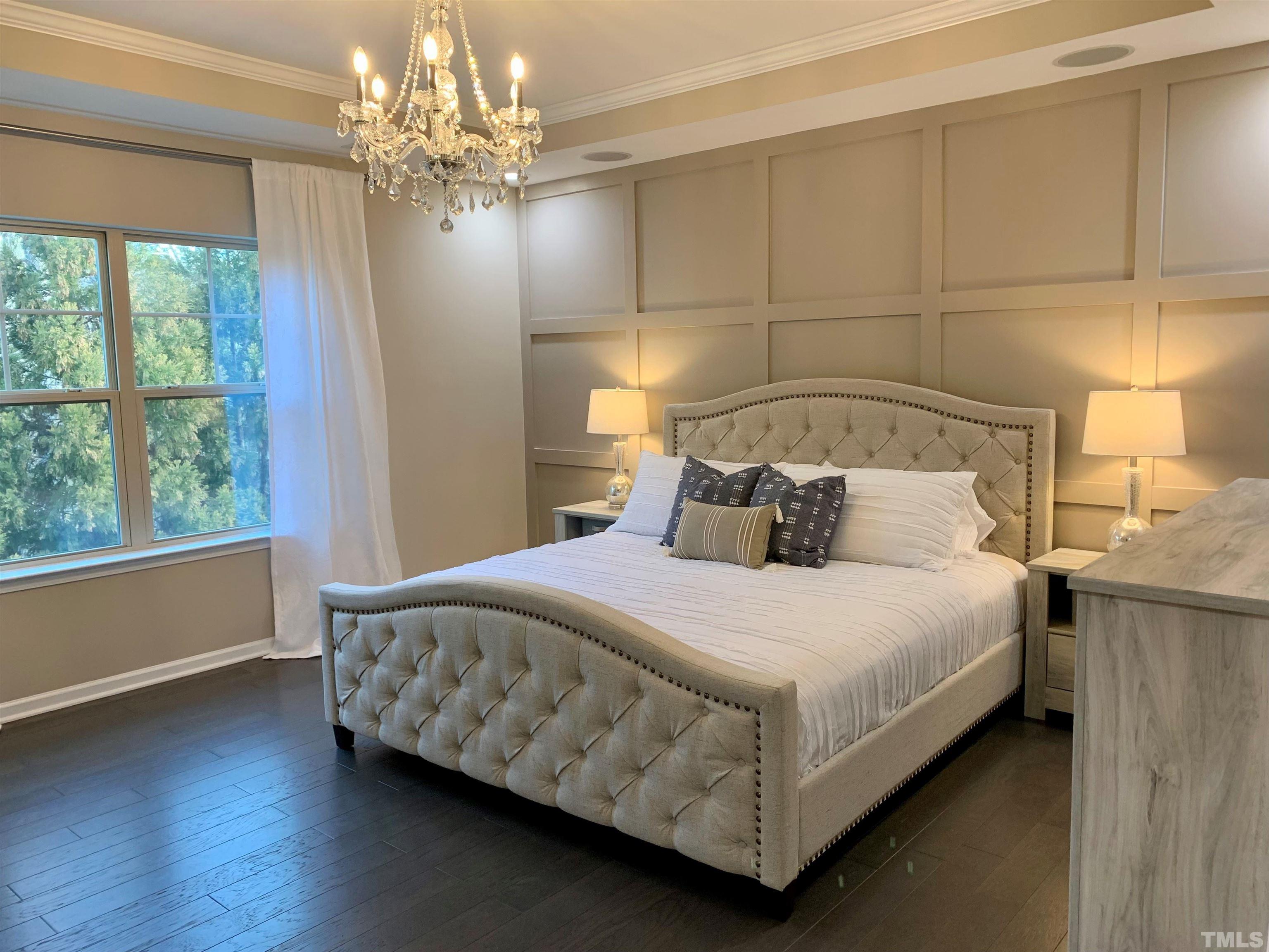 826 Wickham Ridge Road Apex, NC 27539 - Photo 5 of 47 a bedroom with a bed and a chandelier