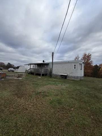 a view of a big house with a big yard and large trees