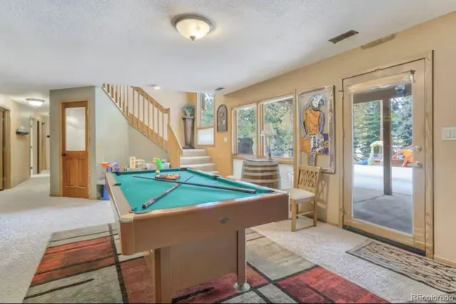 a room with pool table and windows