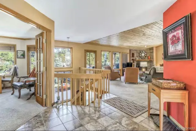 a living room with furniture a fireplace and a dining table with wooden floor