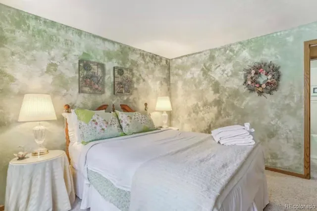 a bedroom with a bed and a wall painting