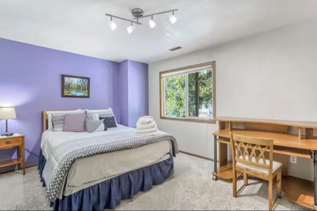 a bedroom with a bed a chair and a large window