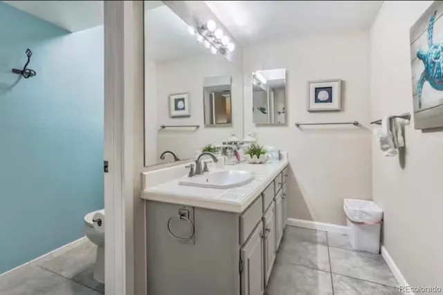 a bathroom with a granite countertop sink a toilet and a mirror