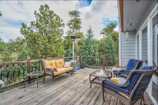 an outdoor sitting area with furniture and wooden floor