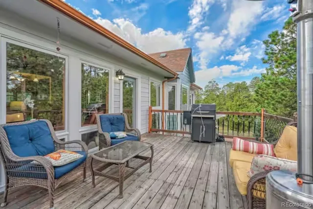 a balcony with wooden floor table and chairs
