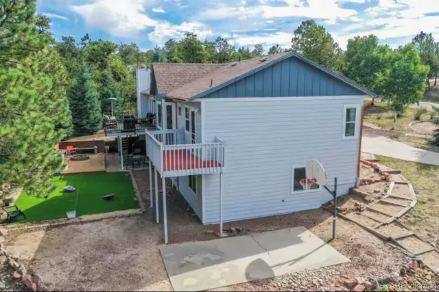 a yellow house with a wooden fence and a yard