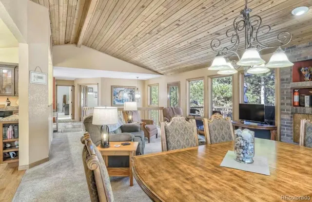a living room with furniture a flat screen tv and large windows