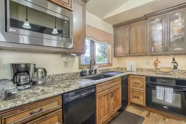 a kitchen with stainless steel appliances granite countertop a sink stove and cabinets