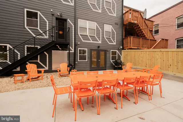 a backyard of a house with barbeque oven table and chairs