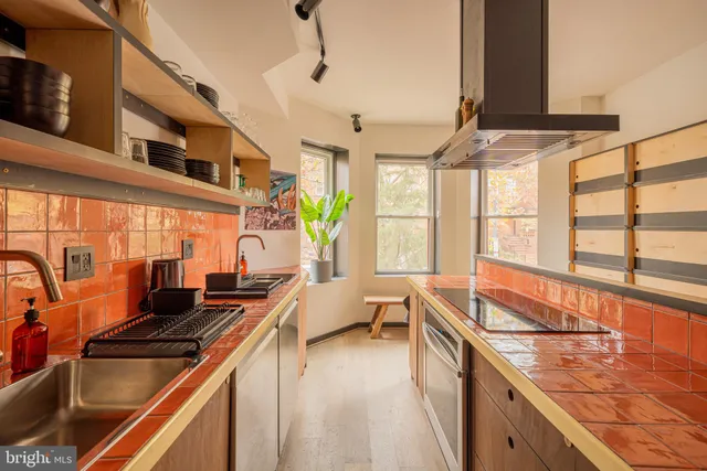 a kitchen with stainless steel appliances granite countertop a sink and a stove