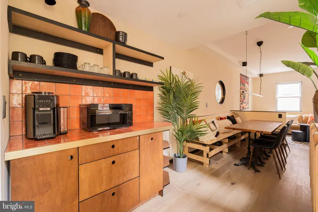 a kitchen with stainless steel appliances kitchen island granite countertop a table and chairs in it