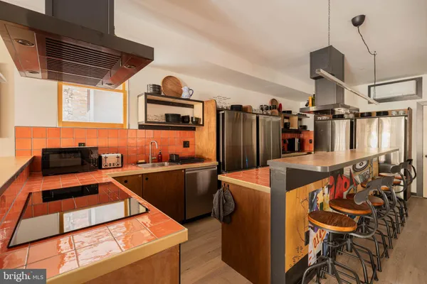 a kitchen with stainless steel appliances granite countertop a sink and a refrigerator