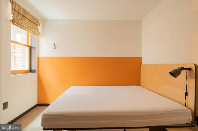 a bed sitting in a bedroom next to a window