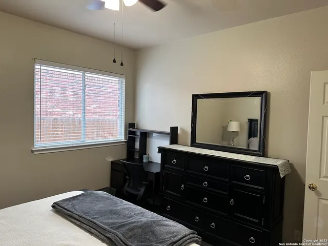 a bedroom with a bed and a flat tv screen on dresser