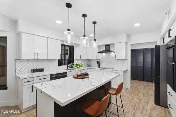 a kitchen with a sink a stove a dining table and chairs