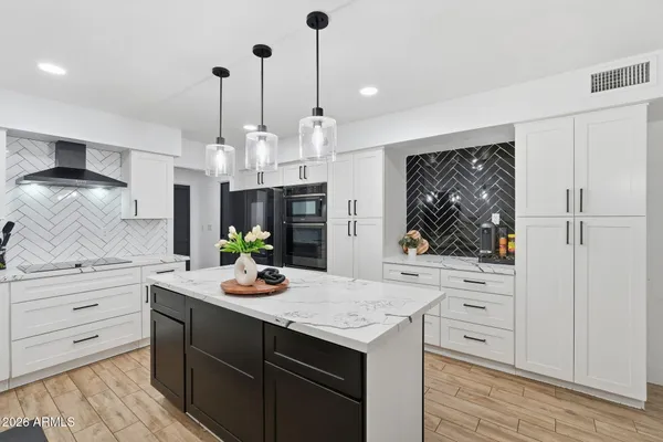 a kitchen with a sink a stove and chairs