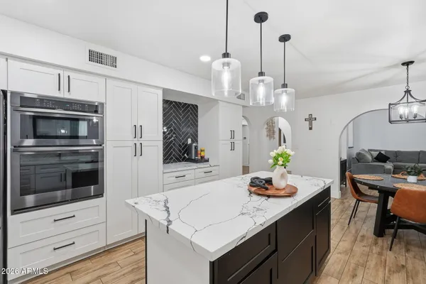 a dining room with furniture a chandelier and wooden floor