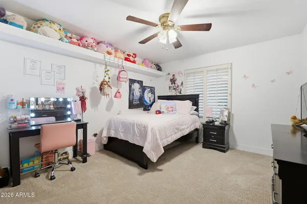 a bedroom with a bed and a flat tv screen on dresser